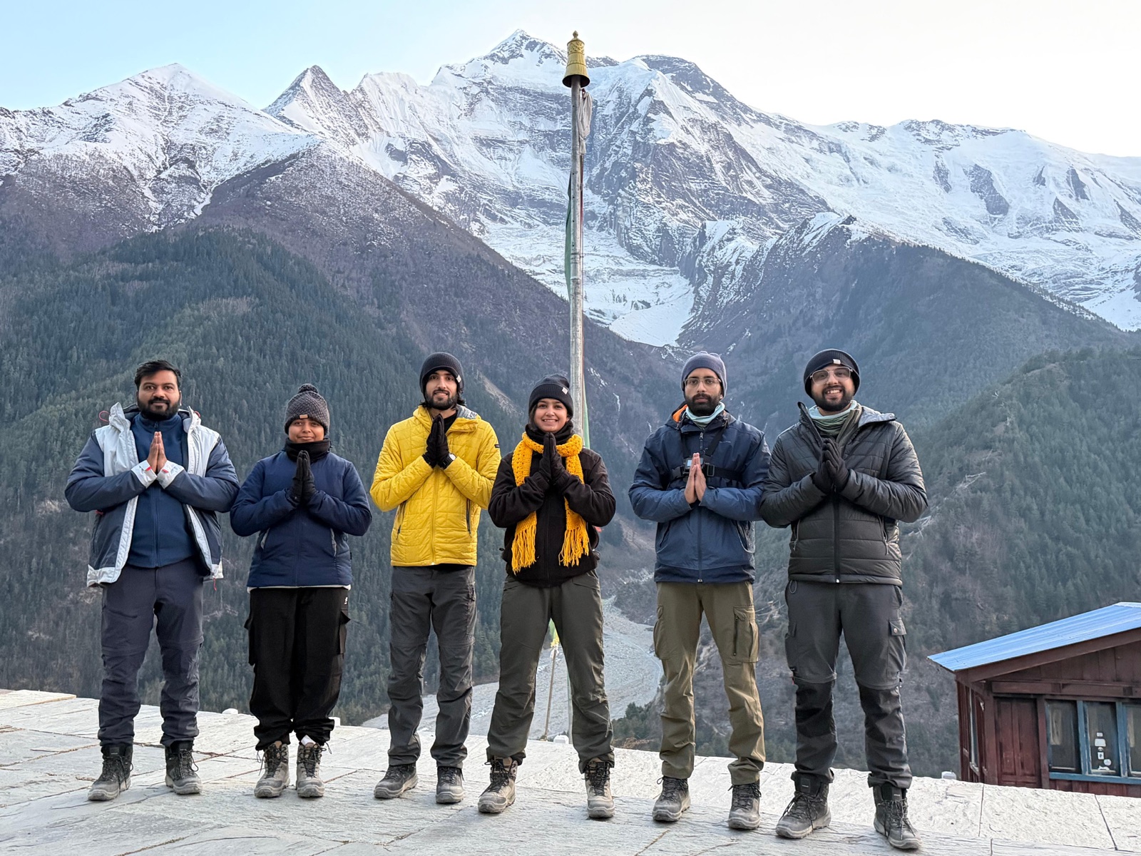 Seekers in prayer pose on a terrace overlooking the Annapurna massif